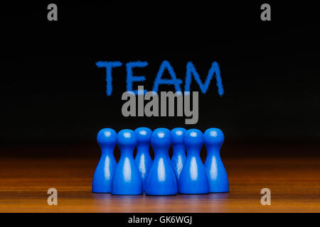 Konzept für: Teamarbeit, Team, Zusammenarbeit, Gruppe, Freunde mit blauer Kreide Text. Blaue Figur Figuren und schwarzem Hintergrund. Stockfoto