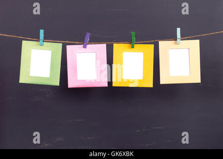 Vier Bilder hängen am Seil auf grauem Hintergrund Stockfoto