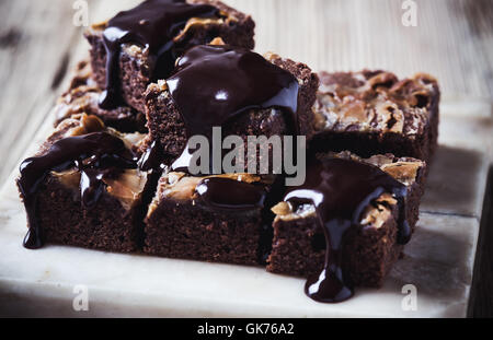 Auf Marmor Stand serviert hausgemachte Karamell-Schokoladen-Brownies mit dunklen Schokoladen ganache Stockfoto
