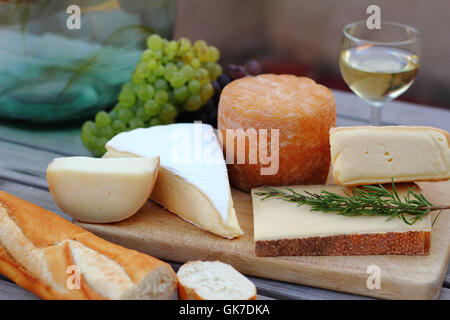 Käseplatte mit Wein, Trauben und Baguette Stockfoto