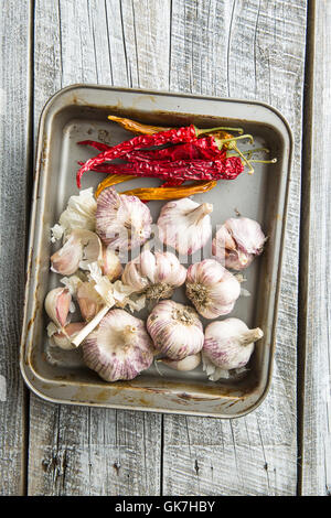 Knoblauch und Chili Peppers auf alten Holztisch. Ansicht von oben. Stockfoto