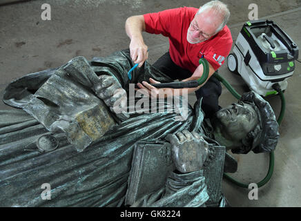 Eisleben, Deutschland. 10. August 2016. Metall-Restaurator Ulrich Weidauer auf der Marthin Luther-Skulptur von Eisleben zur Feier des 500. Jahrestag der Reformation im kommenden Jahr in einer Werkstatt in Eisleben, Deutschland, 10. August 2016 arbeiten. Das Denkmal von Professor Rudolf Siemering (1835 – 1905) wurde im Jahre 1883 zum 400. Geburtstag von Martin Luther auf dem Markt von seiner Heimatstadt Eisleben errichtet. Foto: HENDRIK SCHMIDT/Dpa/Alamy Live News Stockfoto