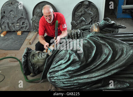 Eisleben, Deutschland. 10. August 2016. Metall-Restaurator Ulrich Weidauer auf der Marthin Luther-Skulptur von Eisleben zur Feier des 500. Jahrestag der Reformation im kommenden Jahr in einer Werkstatt in Eisleben, Deutschland, 10. August 2016 arbeiten. Das Denkmal von Professor Rudolf Siemering (1835 – 1905) wurde im Jahre 1883 zum 400. Geburtstag von Martin Luther auf dem Markt von seiner Heimatstadt Eisleben errichtet. Foto: HENDRIK SCHMIDT/Dpa/Alamy Live News Stockfoto