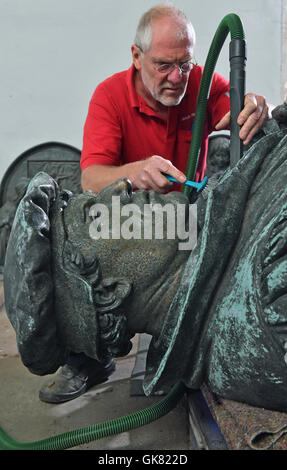 Eisleben, Deutschland. 10. August 2016. Metall-Restaurator Ulrich Weidauer auf der Marthin Luther-Skulptur von Eisleben zur Feier des 500. Jahrestag der Reformation im kommenden Jahr in einer Werkstatt in Eisleben, Deutschland, 10. August 2016 arbeiten. Das Denkmal von Professor Rudolf Siemering (1835 – 1905) wurde im Jahre 1883 zum 400. Geburtstag von Martin Luther auf dem Markt von seiner Heimatstadt Eisleben errichtet. Foto: HENDRIK SCHMIDT/Dpa/Alamy Live News Stockfoto