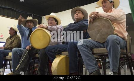 Elgin, Florida, USA. 8. November 2016. Ein Team Ratet mal, wer hat die "Knochen '' wie sie Hand während der Comanche Messe in Elgin, Oklahoma Spiel. Die beiden Teams spielen Handspiel können variieren in der Größe, jedes Team (das Team '' versteckt '' und '' erraten '' Team) müssen einen Kapitän. Das Spiel ist mit zwei Paaren von "Bones", jedes Paar bestehend aus einer Ebene und einem gestreiften Knochen gespielt. Jeder Stamm entscheidet welche Knochen wird erraten, unifarben oder gestreiften Knochen. Oklahoma-Indianer nennen in der Regel für den gestreiften Bone. Die beiden Teams, ein '' versteckt '' und 1 '' raten, '' sitzen einander gegenüber; zwei Mitglieder der t Stockfoto