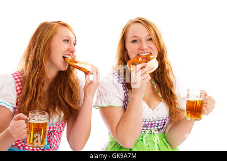 zwei Frauen im Dirndl mit Bier befestigen Brezel Stockfoto