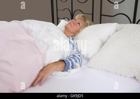 Senior im Bett liegend Stockfoto