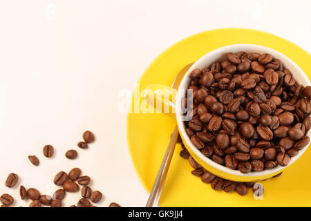 gelbe Tasse mit Kaffeebohnen Stockfoto