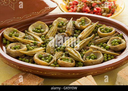 Marokkanische Oval Tajine mit Fleisch, Okra, grüne Erbsen und Artischockenherzen Stockfoto