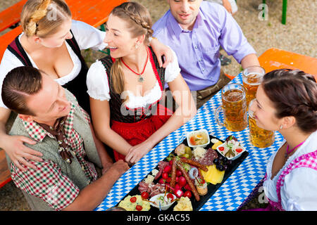 im Biergarten - Freunde in Tracht am biertisch Stockfoto