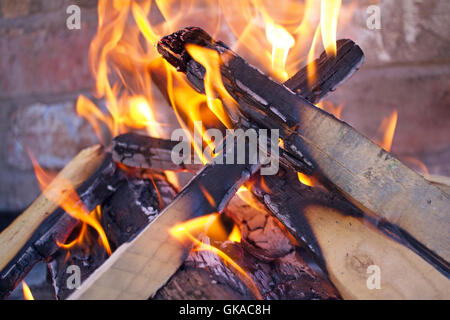 Holzofen, offener Flamme auf einem Ziegelstein gebaut Bbq. Drechslerei, Holzkohle. Orange Flammen wie Holz in ein Feuer brennt Stockfoto