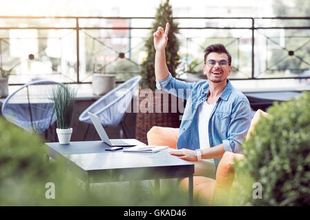 Fröhlicher Mensch sitzt im café Stockfoto