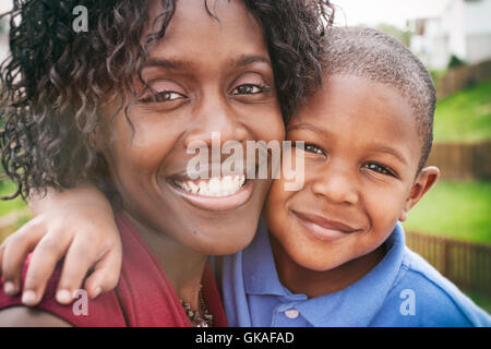 African American Mutter und Sohn machen Cookies in Küche und in verschiedenen Posen auf weißem Hintergrund. Stockfoto