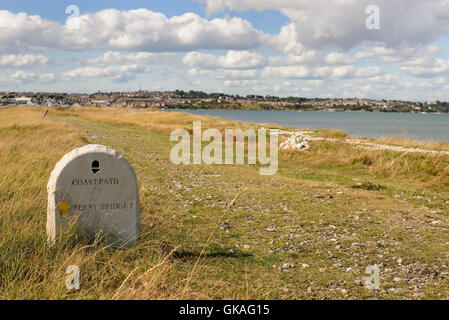 Ein Stein Wegpunkt entlang der South West Coast Path zwischen Weymouth und Portland, auf der Trasse einer alten Eisenbahnlinie. Stockfoto