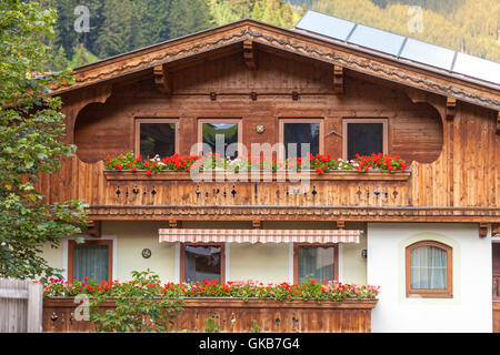 Traditionelle österreichische Häuser mit Blumen in den Fenstern in Tux, Zillertal Stockfoto