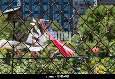 Städtischen Stadtgarten mit Maschendrahtzaun mit amerikanischen Flagge im Hintergrund. Stockfoto