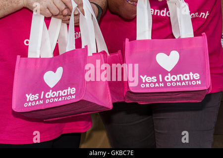 "Ja ich Spenden 'Pink Taschen. Junge Evie Pownall, Mädchen 6 Jahre alt mit wiederverwendbaren Rosa tasche Weiterempfehlen Registrierung für Organspende, Southport, Großbritannien Stockfoto