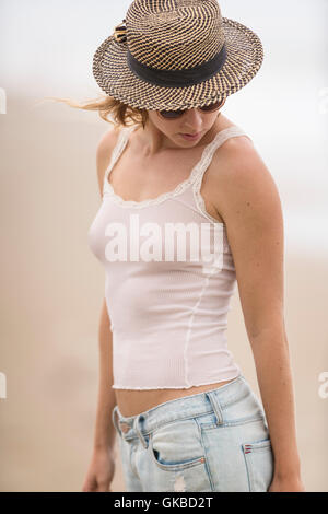 Junge blonde Frau in einem weißen Tank-Top und Hut Stockfoto