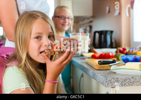 Familie - Mutter macht Frühstück für die Schule Stockfoto