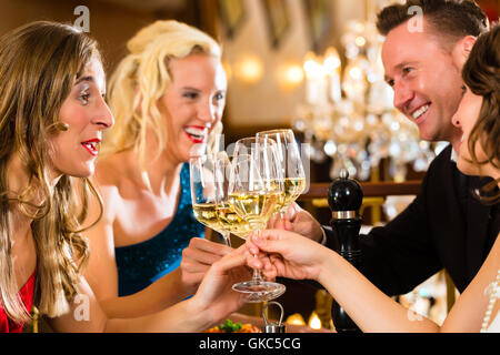 Freunde in einem sehr guten Restaurant stoßen Stockfoto