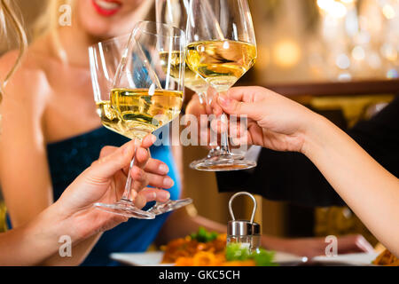 Freunde in einem sehr guten Restaurant stoßen Stockfoto