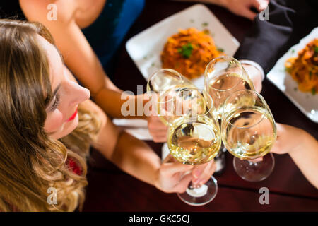 Freunde in einem sehr guten Restaurant stoßen Stockfoto