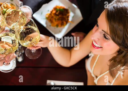 Freunde in einem sehr guten Restaurant stoßen Stockfoto