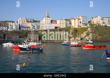 Frühlingssonne auf die Pastell farbigen Häuser rund um den malerischen Hafen von Tenby, Pembrokeshire, Wales Stockfoto