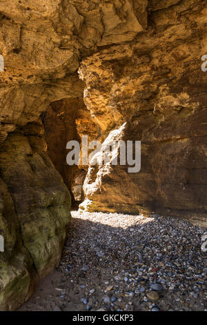 Höhlen von Klippen von Gelben magnesiumhaltigen Kalkstein in Seaham Strand, County Durham, UK erodiert Stockfoto