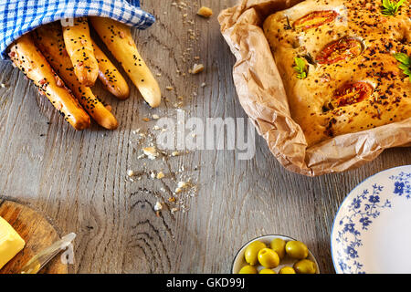Traditionelle Focaccia und Brot-Sticks, rustikale Einrichtung auf einem Holztisch von oben. Stockfoto
