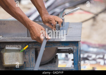Professionelle Arbeiter schneiden Aluminium mit Mahlwerk Klinge Stockfoto