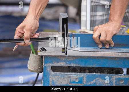 Professionelle Arbeiter schneiden Aluminium mit Mahlwerk Klinge Stockfoto