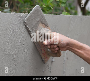 Hand der Erbauer Arbeiter benutzen Kelle Beton Wand verputzen Stockfoto