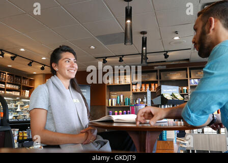 Eine Seite der Leute trinken Kaffee und diskutieren Sache innerhalb Starbucks Filiale Stockfoto