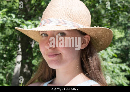 Junge und schöne Frau mit Hut weit wegschauen. Mädchen glücklich Sommersonne Stockfoto