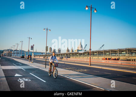 Ein einsamer Radfahrer auf dem Fahrrad-Superhighway auf einer fast verlassenen Blackfriars Bridge, London, England, Großbritannien Stockfoto