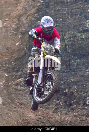 Mann-Biker zieht einen Wheelie auf der auf einem Feldweg Stockfoto