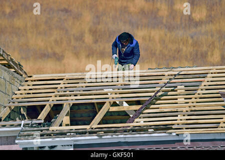Arbeiter in Gläsern mit einem Bohrer Reparatur Dach Stockfoto