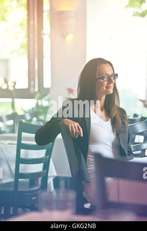 Porträt einer glücklich und hübsche junge Frau sitzt in einem restaurant Stockfoto