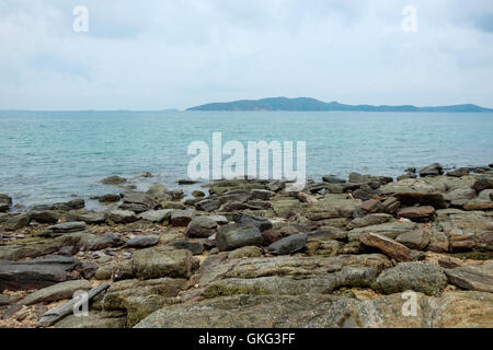 Felsen am Ufer mit Meer- und Bergblick Hintergrund bei Khao Laem Ya, Mu Ko Samet Nationalpark in Thailand. Stockfoto