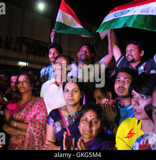 Hyderabad, indischen Bundesstaat Telangana. 19. August 2016. P. V. Ramna (in weiß) und P. Vijaya (in rot), Eltern von indische Badmintonspielerin P. V. Sindhu, sehen ihre Tochter Damen-Einzel-Finale der Rio-Olympische Spiele 2016 gegen Spaniens Carolina Marin vor einem riesigen Bildschirm Gopichand Academy in Hyderabad, südindischen Bundesstaat Telangana, 19. August 2016. © Stringer/Xinhua/Alamy Live-Nachrichten Stockfoto