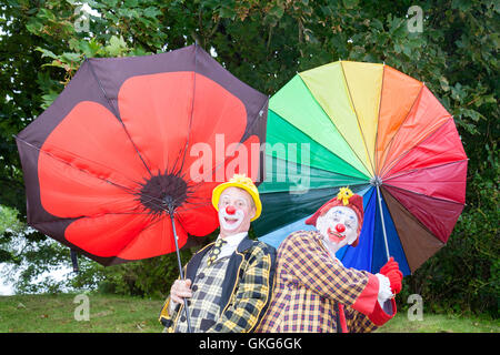 Southport, Merseyside. Großbritannien Wetter: 20. August 2016.Weather: 20. August 2016.  Starke Winde und Stürme Southport, Sonny & Rainbow Kampf ihre Regenschirme festhalten getroffen.  Als zwei der lustigsten Clowns herum können sie alltägliche Situationen in lustige Szenarien wenden.  Die Massen waren überwältigt von ihrer Eskapaden als das schlechte Wetter schlug noch einmal über die Massen auf der Southport Flower Show.  Bildnachweis: Cernan Elias/Alamy Live-Nachrichten Stockfoto