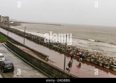 Sandylands Promenade Morecambe, Lancashire, Vereinigtes Königreich. 20. August 2016. Schlechtes Wetter schwere Regenfälle und Windböen können nicht davon abhalten, jeweils von einem Spaziergang Daown der Promeanade bei der Morecambe Credit: David Billinge/Alamy Live News Stockfoto