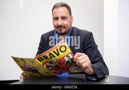 München, Deutschland. 11. August 2016. Journalist und ehemaliger Chefredakteur des jugendlich Zeitschrift Bravo, Alex Gernandt, hält die erste Ausgabe der Bravo von 26.08.1956, in München, Deutschland, 11. August 2016. Das Magazin feiert sein 60-jähriges bestehen auf 26.08.2016. Foto: SVEN HOPPE/DPA/Alamy Live-Nachrichten Stockfoto