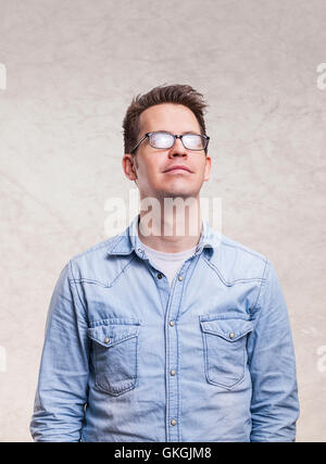Porträt eines entspannten jungen Mannes nach oben - auf leichten grauen Wand Hintergrund isoliert Stockfoto