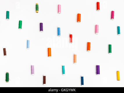 viele Spulen Nähgarn auf weißem Hintergrund Stockfoto