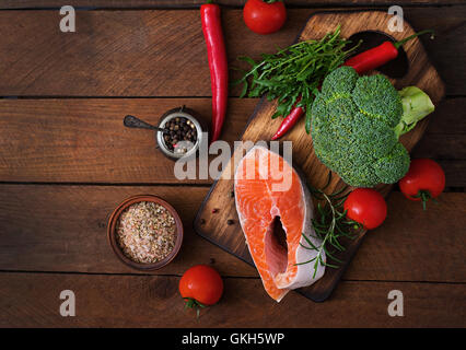 Rohes Steak Lachs und Gemüse zum Kochen auf hölzernen Hintergrund im rustikalen Stil. Diät-Menü. Die richtige Ernährung. Ansicht von oben Stockfoto
