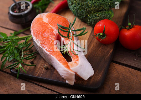 Rohes Steak Lachs und Gemüse zum Kochen auf hölzernen Hintergrund im rustikalen Stil. Diät-Menü. Die richtige Ernährung. Stockfoto
