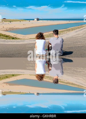 Fata Morgana: Paar sitzt auf dem Damm führt zum Strand, wo die Mündung des Flusses Rhein in die Nordsee mündet. Stockfoto