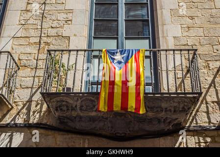 Flagge der Unabhängigkeitsbewegung von Katalonien, genannt Estelada (inoffiziell) in einer Straße der Innenstadt von Girona, Costa Brava, Spanien. Stockfoto